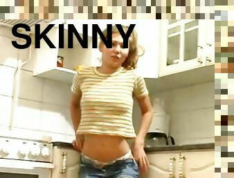 Skinny teenager in short shorts teases in kitchen