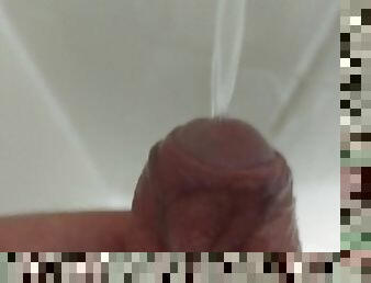 Piss in the shower into the wall with foreskin peeled back