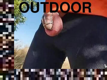 Locked in chastity cage cyclist man is pissing outdoor