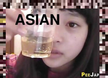 asian teen urinates in plastic glass