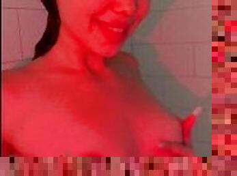 Baby in the shower rubs her bare tits.