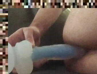 Playing with a dildo on the couch