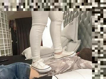 Trampling with white sneakers in bed