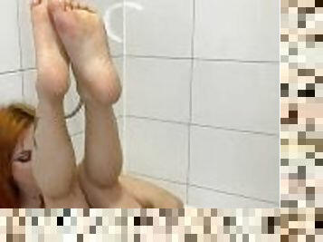 Redhead masturbates right on the bathroom floor, pink dildo fondles redhead.