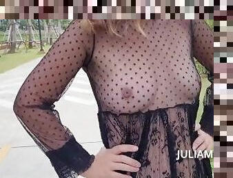 Lustful girl in a transparent dress in a public park